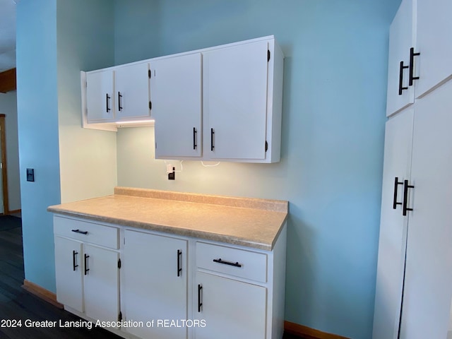 kitchen with hardwood / wood-style floors and white cabinetry