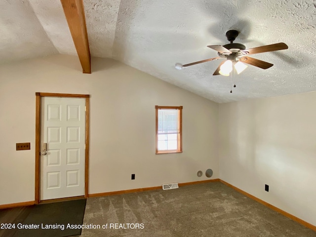 carpeted spare room featuring lofted ceiling with beams, ceiling fan, and a textured ceiling