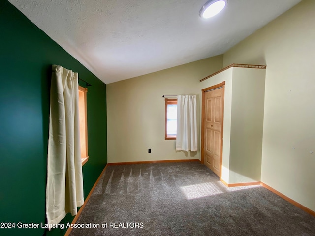 unfurnished bedroom featuring carpet flooring and vaulted ceiling