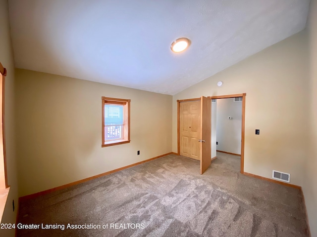 unfurnished bedroom with light carpet and vaulted ceiling