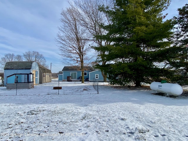 yard covered in snow with a storage shed