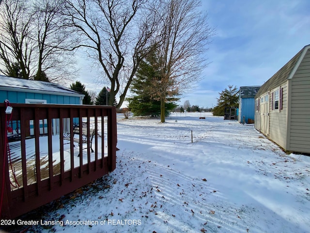 yard covered in snow with a deck