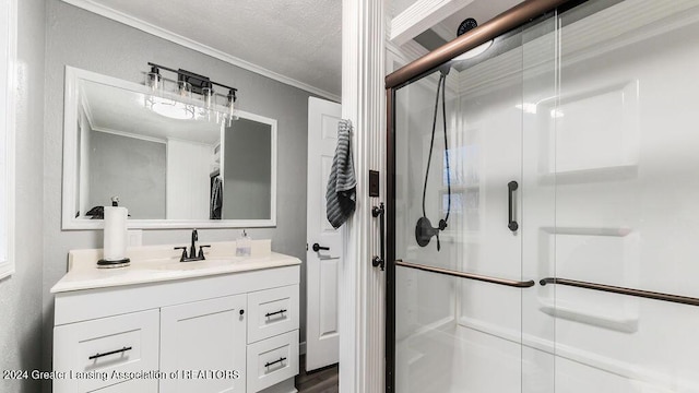 bathroom with a textured ceiling, vanity, a shower with door, and crown molding