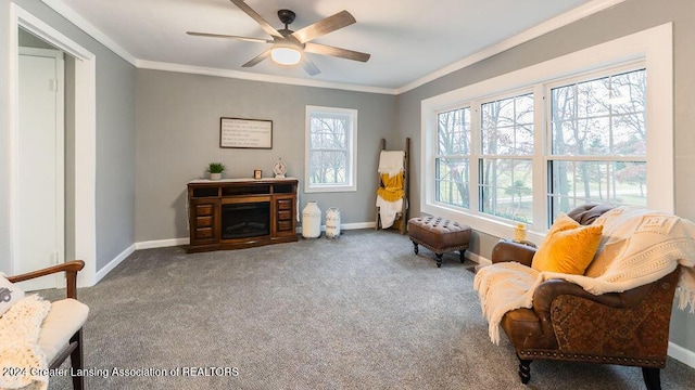 sitting room with carpet, ceiling fan, and crown molding