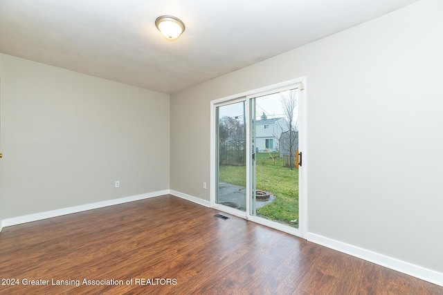 empty room with dark hardwood / wood-style flooring