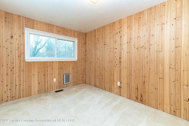 unfurnished room with carpet floors and wooden walls