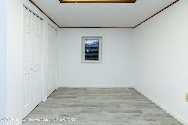 interior space featuring crown molding and light hardwood / wood-style flooring