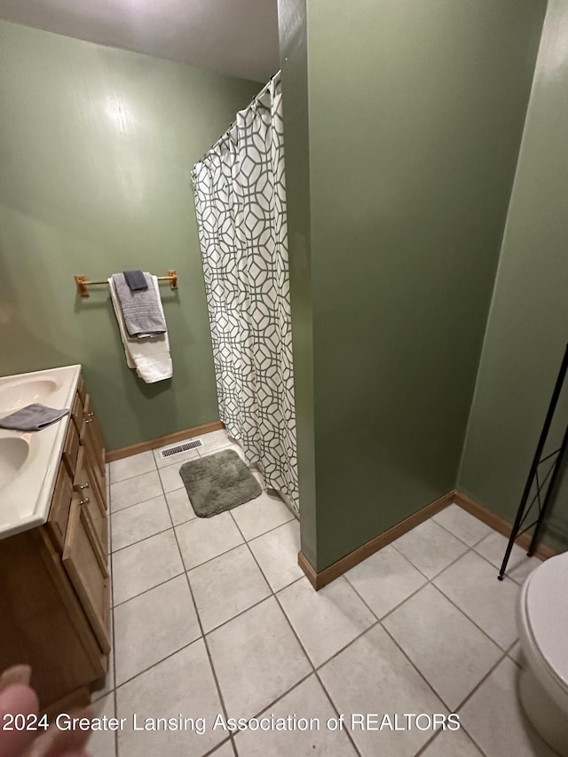 bathroom with tile patterned flooring, vanity, and toilet