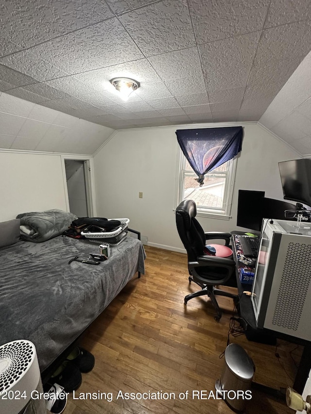 bedroom featuring hardwood / wood-style floors and lofted ceiling