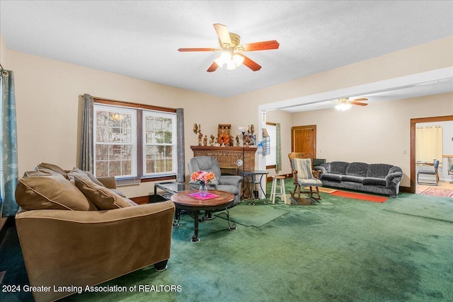 carpeted living room featuring ceiling fan and a textured ceiling