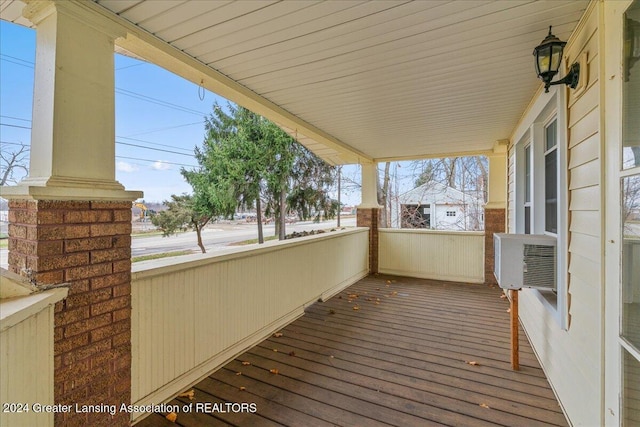 wooden deck with covered porch and cooling unit