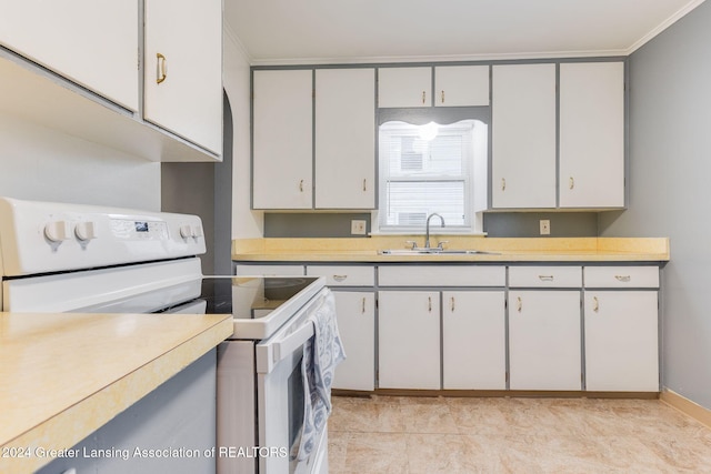 kitchen featuring electric range, sink, light tile patterned floors, white cabinets, and ornamental molding