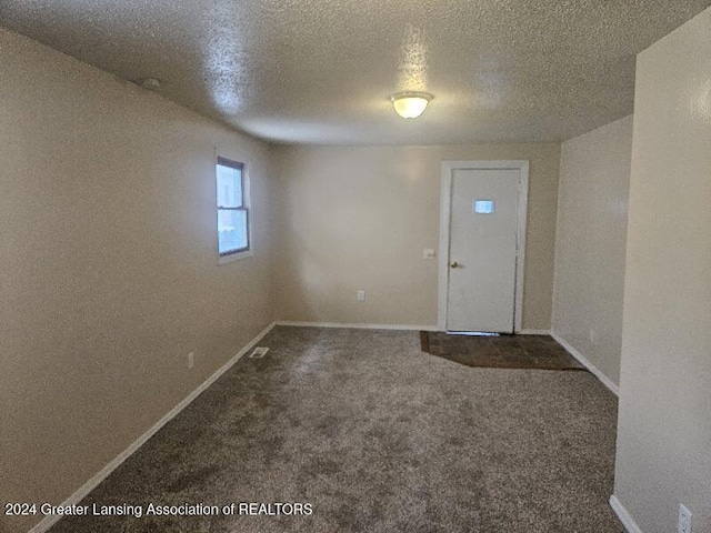 carpeted entryway featuring a textured ceiling