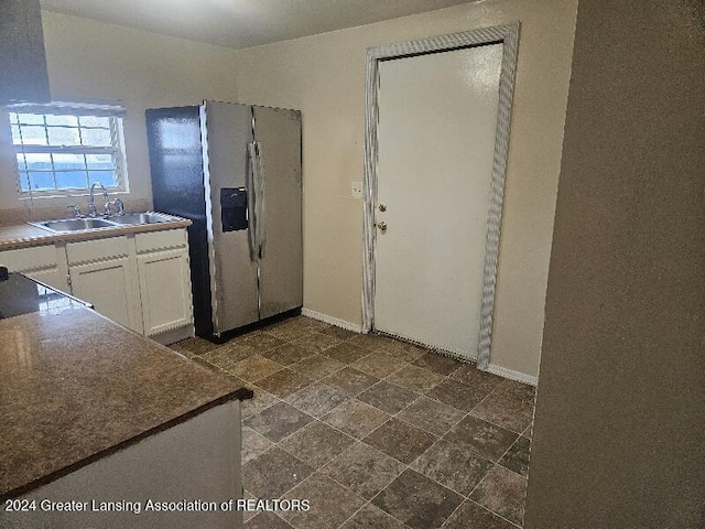 kitchen with sink, white cabinets, and stainless steel refrigerator with ice dispenser