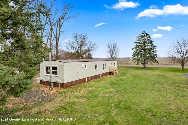 back of property with a yard and a rural view