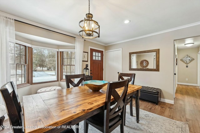 dining room featuring a notable chandelier, crown molding, and light hardwood / wood-style flooring