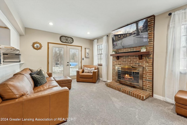 carpeted living room featuring a brick fireplace and french doors