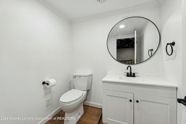 bathroom featuring ornamental molding, vanity, wood-type flooring, and toilet