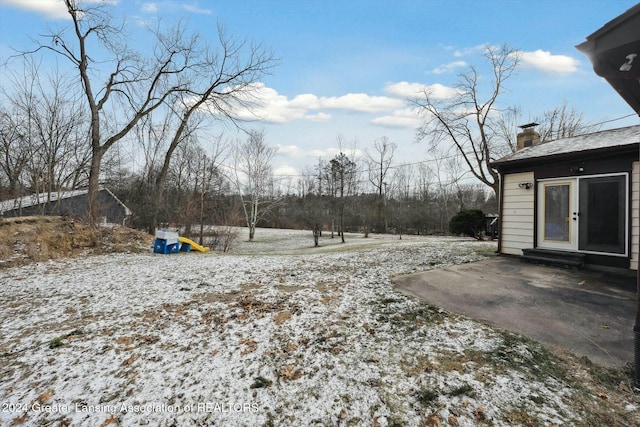 yard covered in snow with a patio area