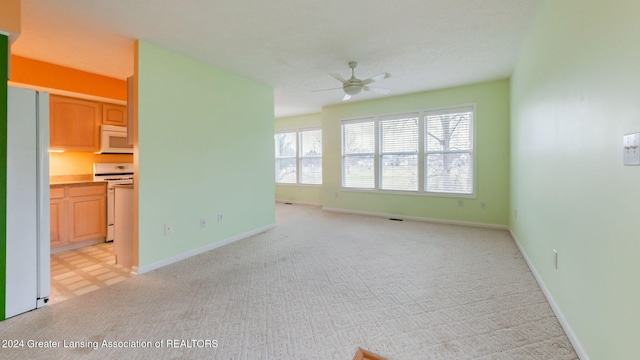 unfurnished living room with light colored carpet and ceiling fan