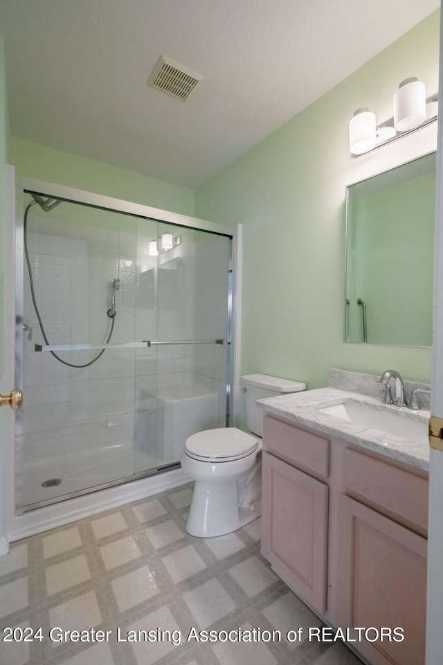 bathroom featuring toilet, vanity, and walk in shower