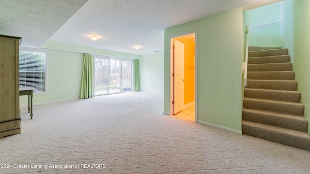 carpeted empty room featuring a textured ceiling