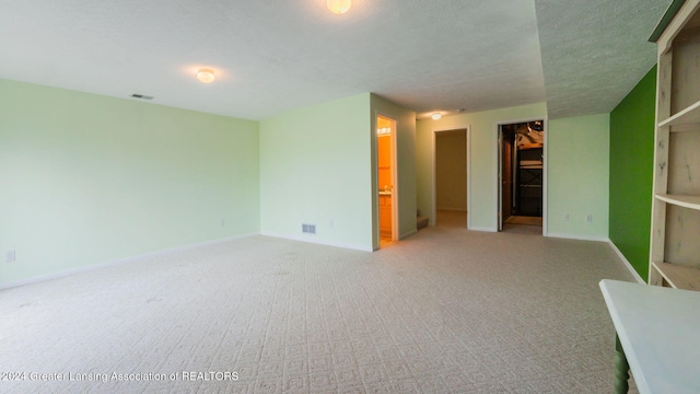 carpeted spare room with a textured ceiling