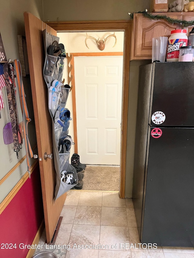 interior space featuring light tile patterned floors and fridge