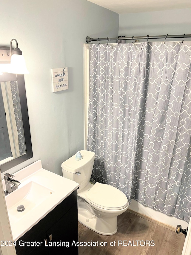 bathroom featuring a shower with curtain, vanity, hardwood / wood-style flooring, and toilet