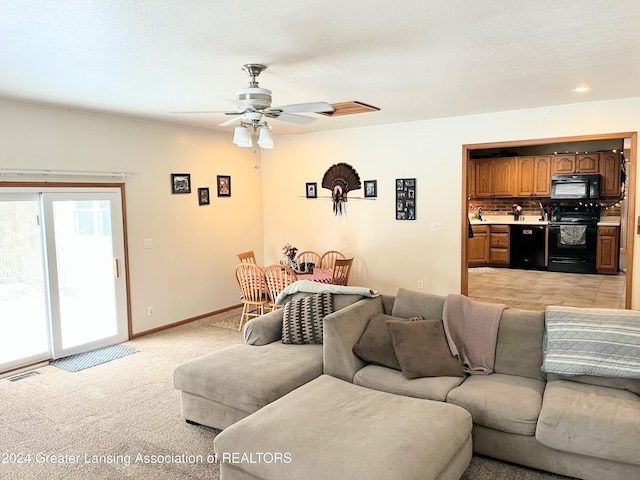 living room featuring ceiling fan, light colored carpet, and a textured ceiling