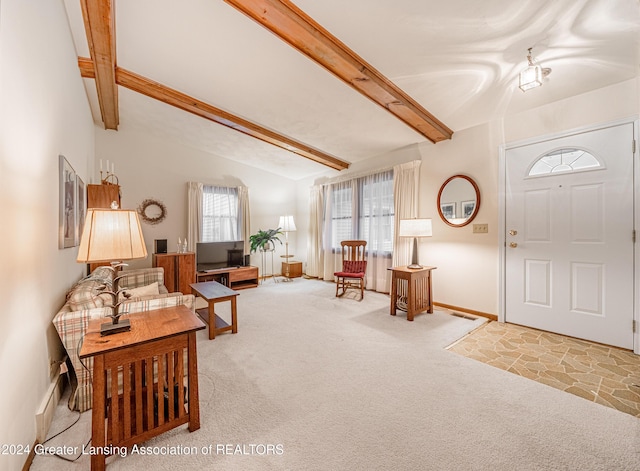 carpeted foyer featuring vaulted ceiling with beams