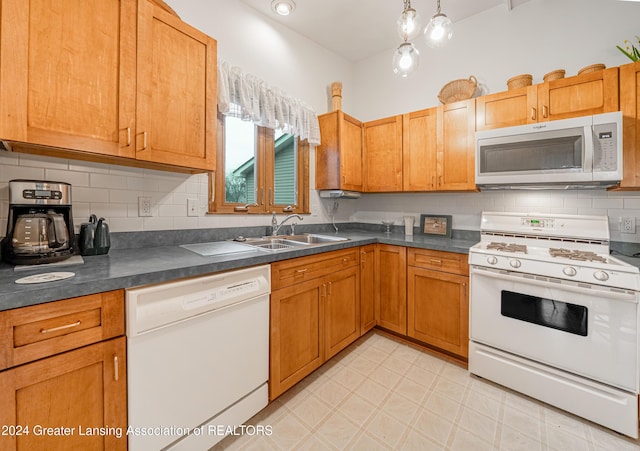 kitchen with decorative backsplash, sink, decorative light fixtures, and white appliances