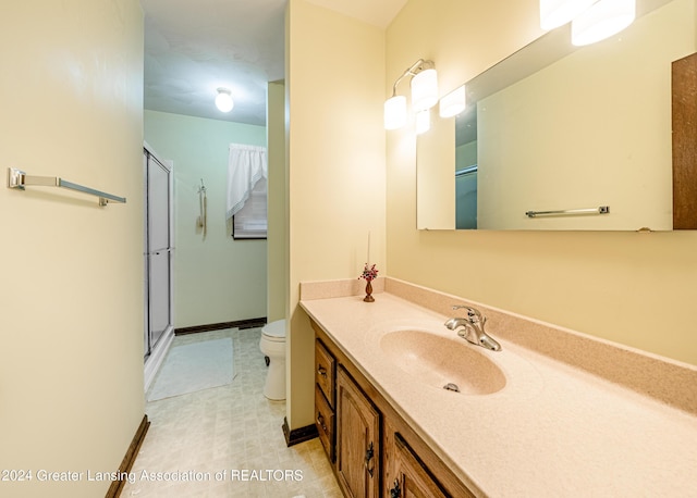 bathroom featuring vanity, toilet, and a shower with shower door