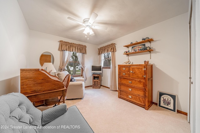 living area with ceiling fan and light carpet