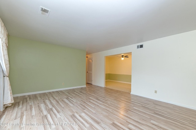 empty room with ceiling fan and light hardwood / wood-style floors