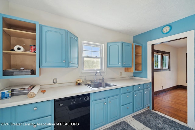 kitchen with blue cabinetry, dishwasher, sink, a textured ceiling, and light wood-type flooring