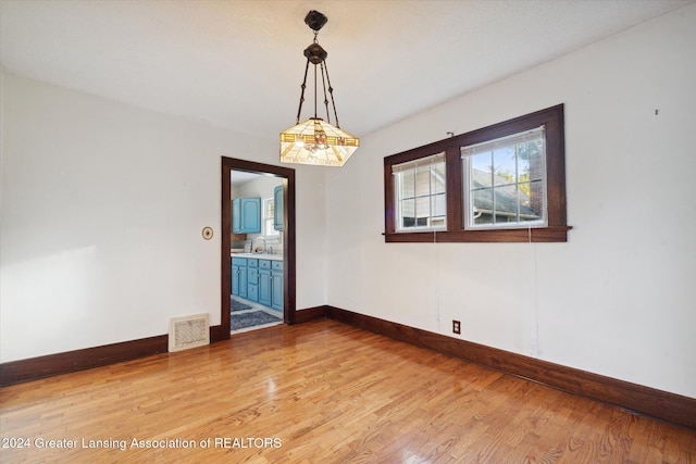 empty room featuring sink and hardwood / wood-style flooring