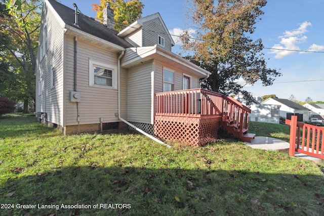 back of house with a lawn and a wooden deck