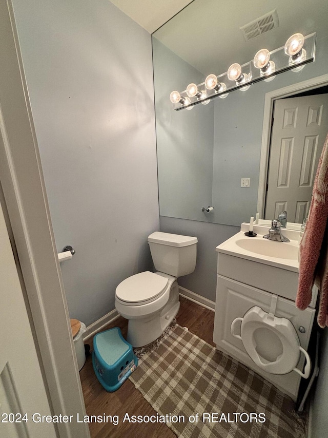 bathroom featuring hardwood / wood-style flooring, vanity, and toilet