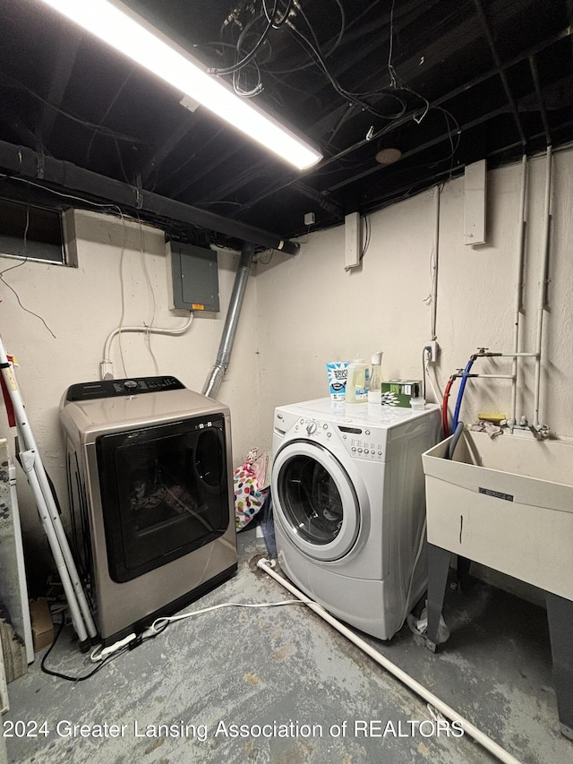 laundry room featuring electric panel and washer and dryer