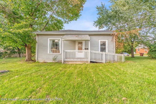 view of front of property with a wooden deck and a front lawn