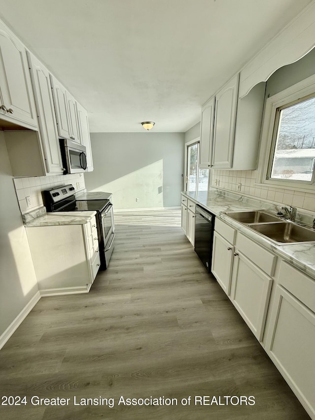 kitchen with a wealth of natural light, white cabinets, and appliances with stainless steel finishes