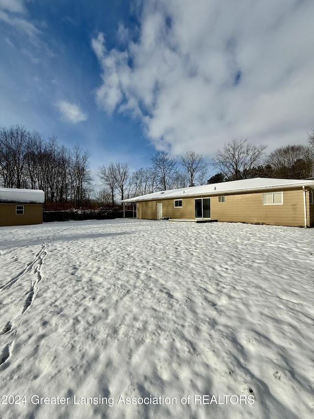 view of snow covered back of property