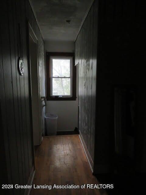 hall featuring wood walls and dark wood-type flooring