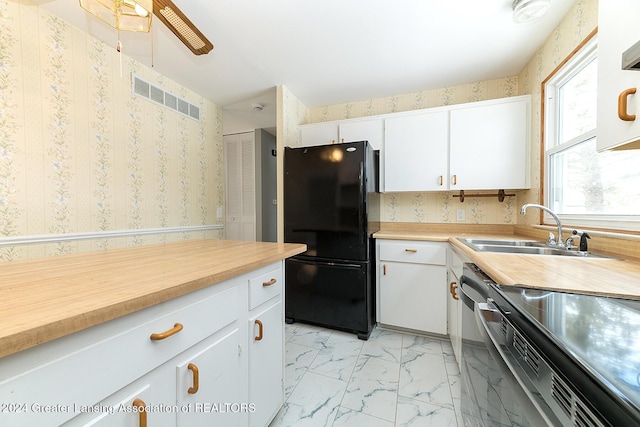 kitchen with white cabinets, black fridge, range, and sink