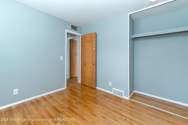 unfurnished bedroom with light hardwood / wood-style floors and a closet