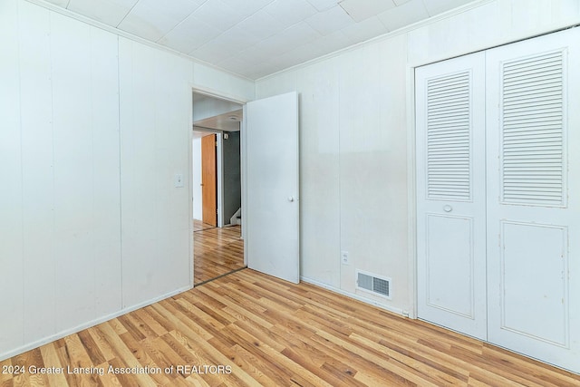 unfurnished bedroom featuring light wood-type flooring and a closet