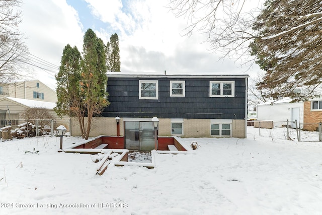 view of snow covered rear of property