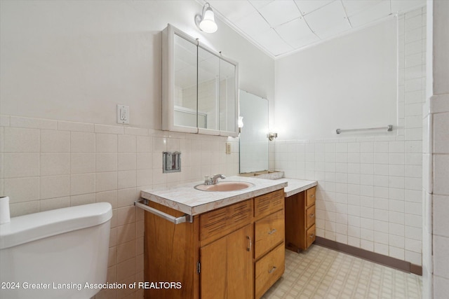 bathroom featuring vanity, toilet, tile walls, and crown molding