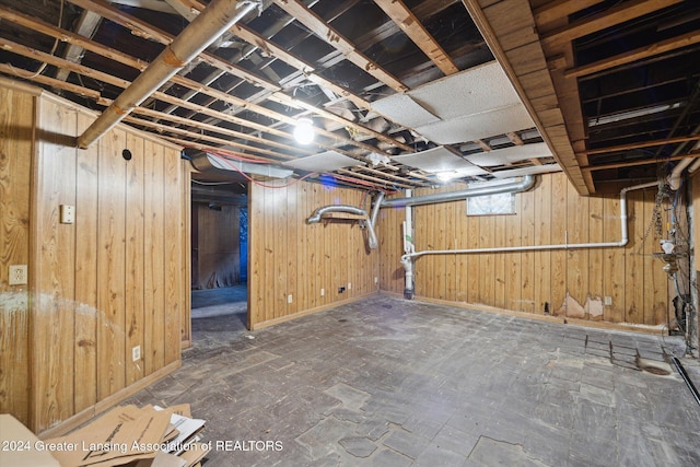 basement featuring wooden walls